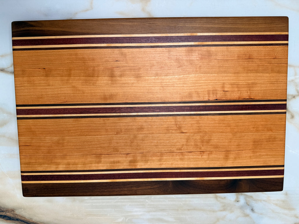 Heritage Cutting Board 18” × 12” × 1.5” — Maple, Walnut, Cherry & Purple Heart | Juice Groove + Hand Holds