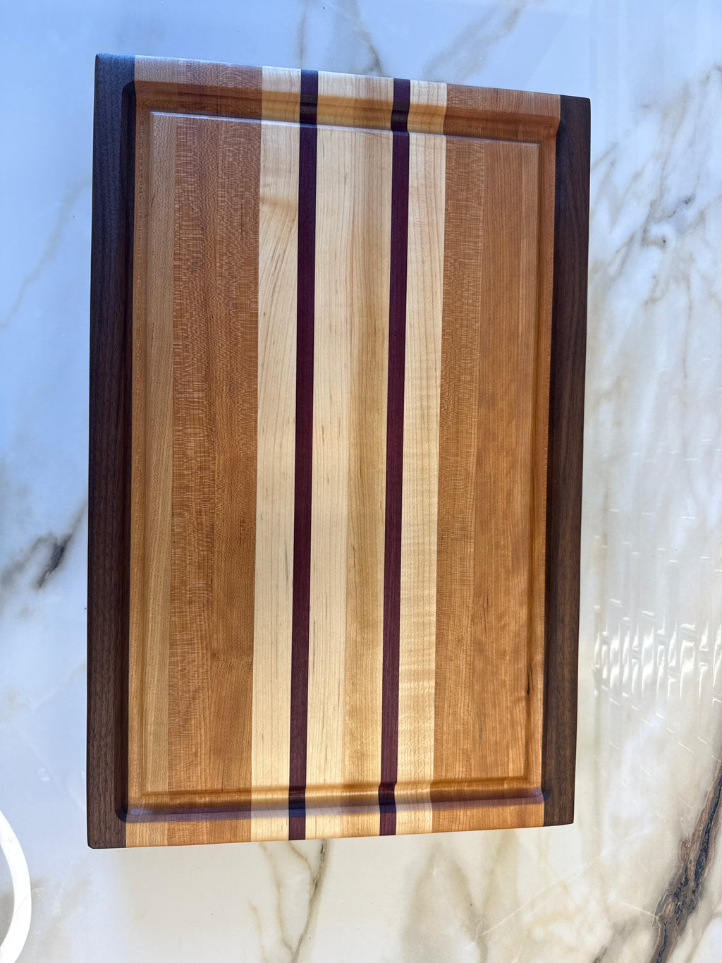 Heritage Cutting Board 18” × 12” × 1.5” — Maple, Walnut, Cherry & Purple Heart | Juice Groove + Hand Holds with brass feet