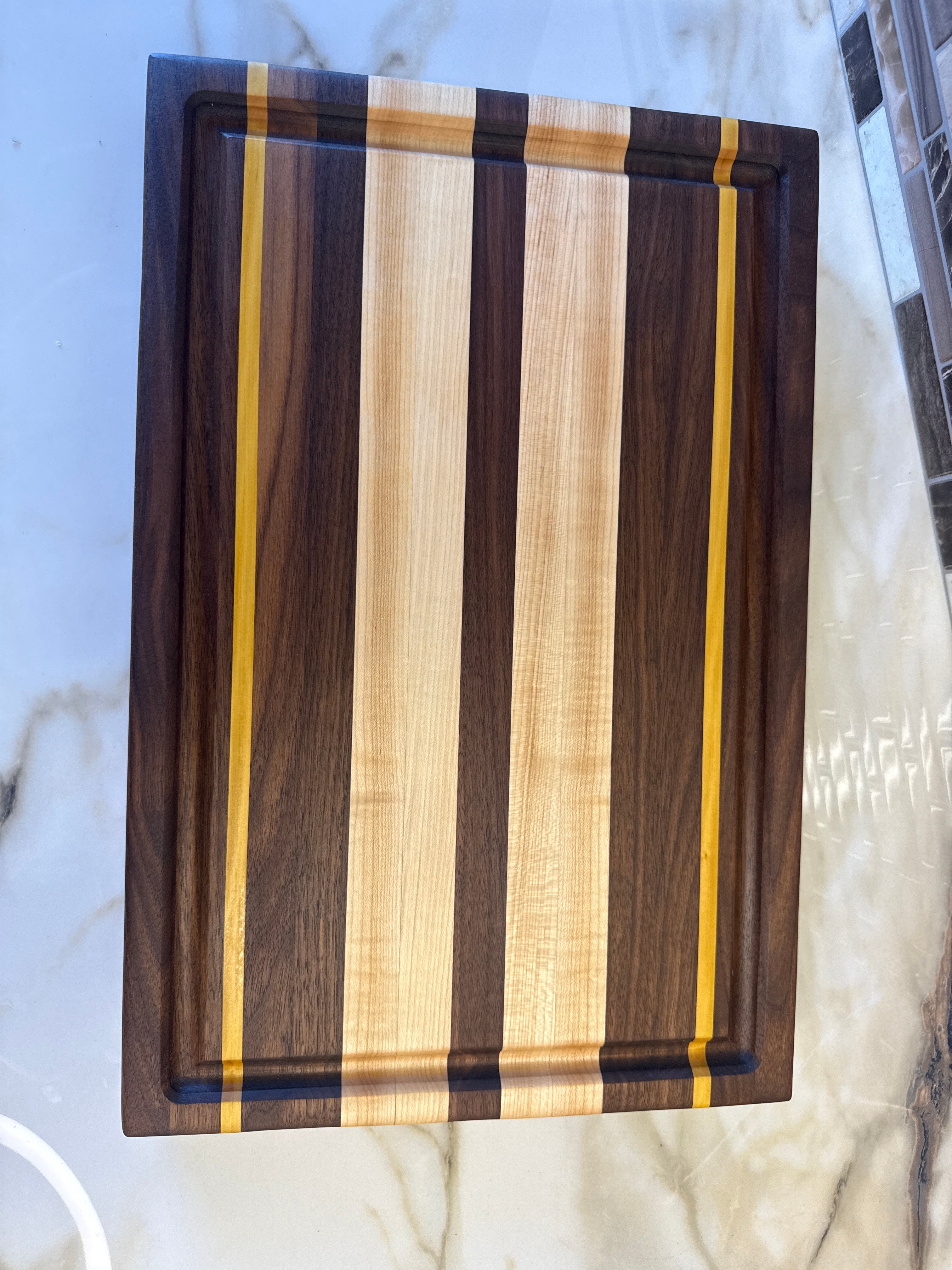 Heritage Cutting Board 18” × 12” × 1.5” — Maple, Walnut, & Yellow Heart | Juice Groove + Hand Holds with brass feet