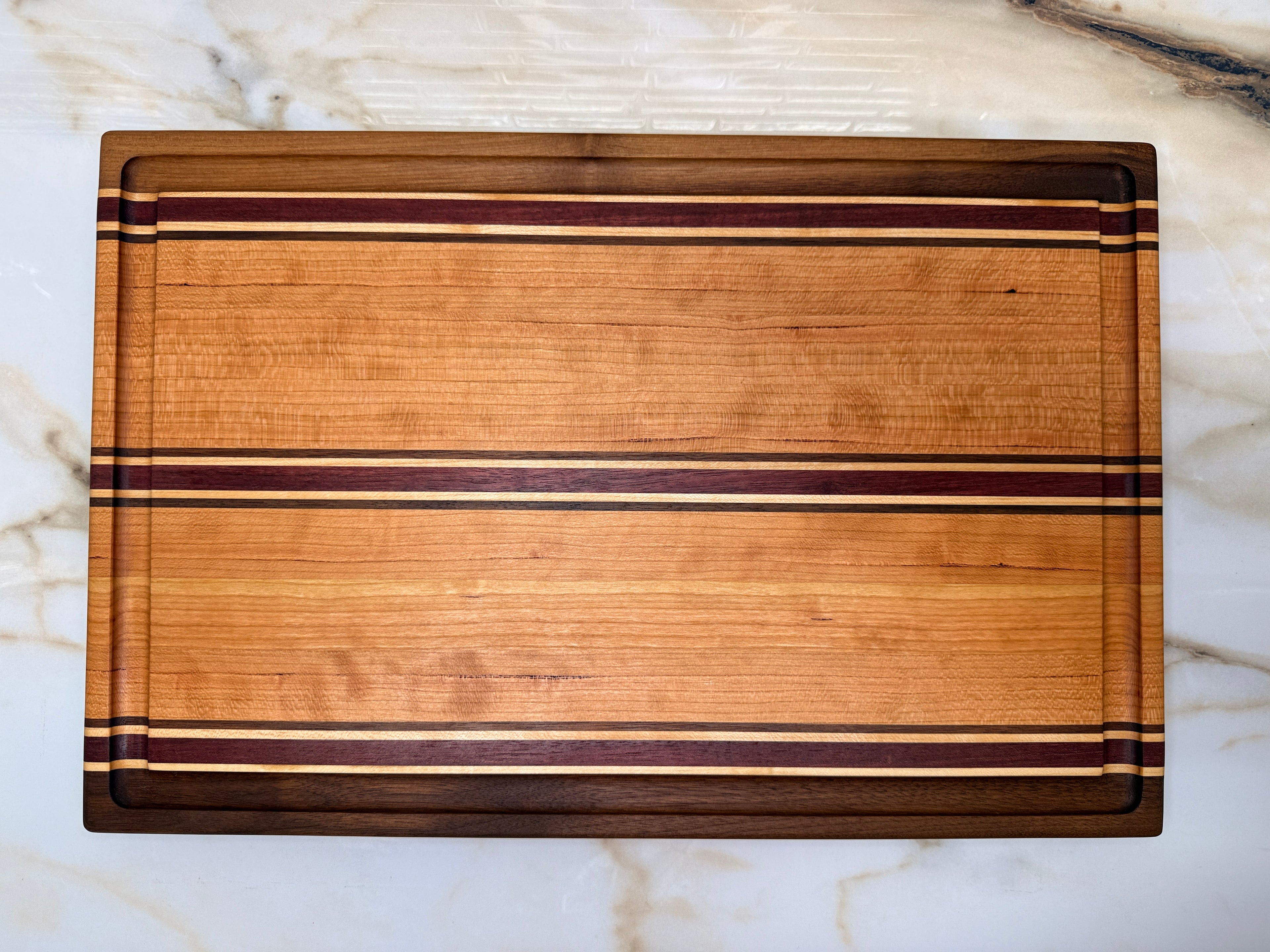 Heritage Cutting Board 18” × 12” × 1.5” — Maple, Walnut, Cherry & Purple Heart | Juice Groove + Hand Holds